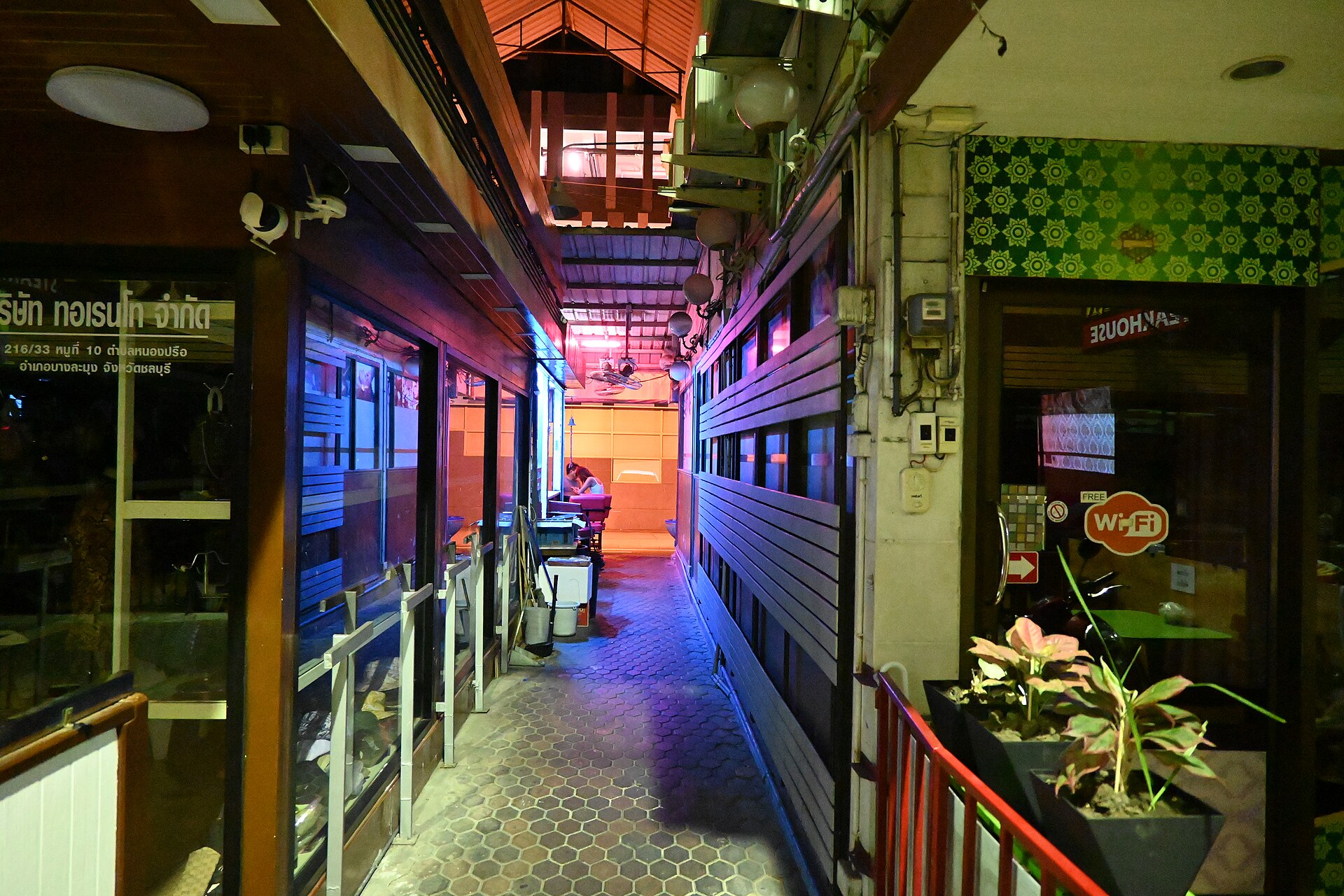 Neon-lit alley of small shops and cafes in the evening